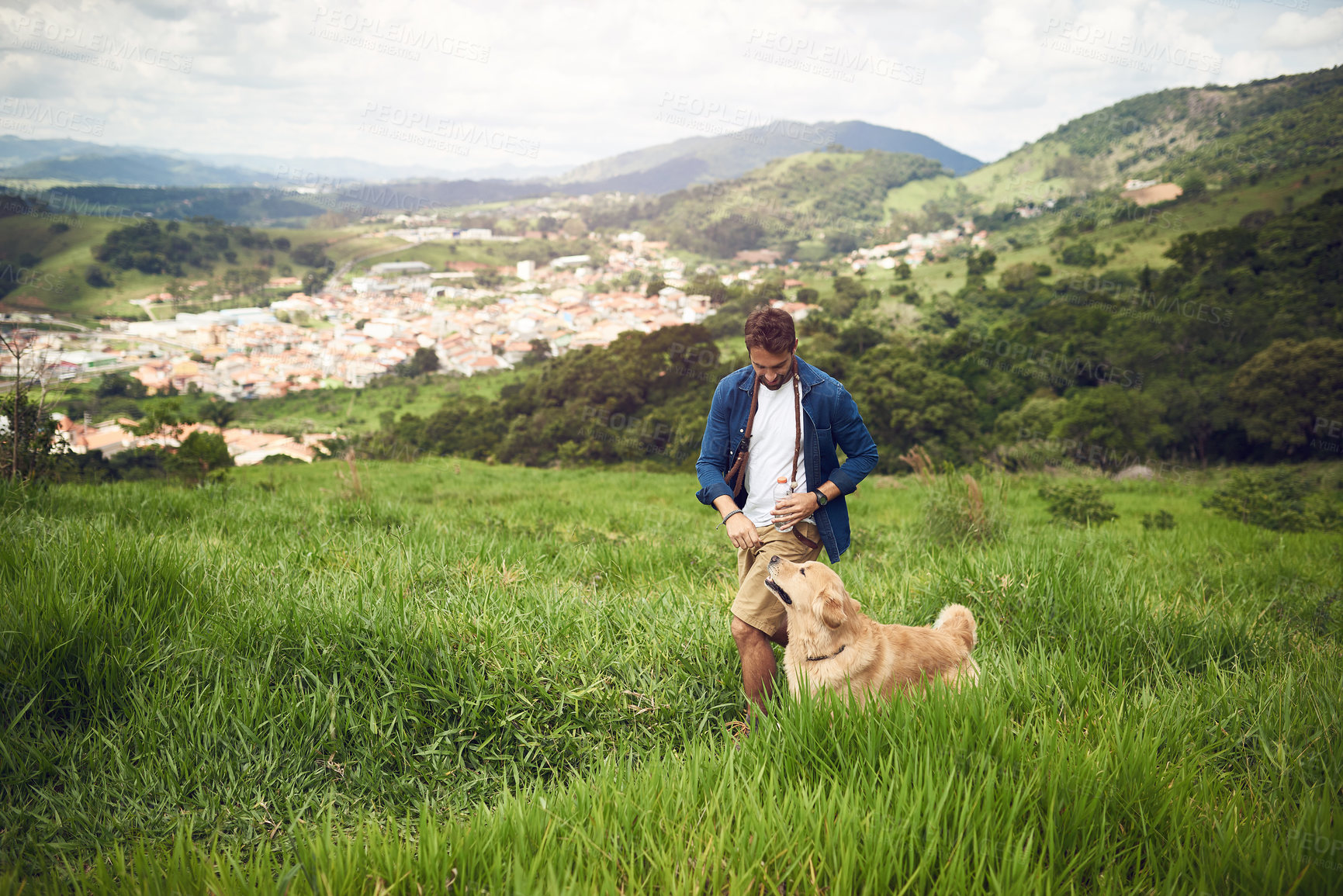 Buy stock photo Full length shot of a handsome young man walking with his golden retriever during a hike