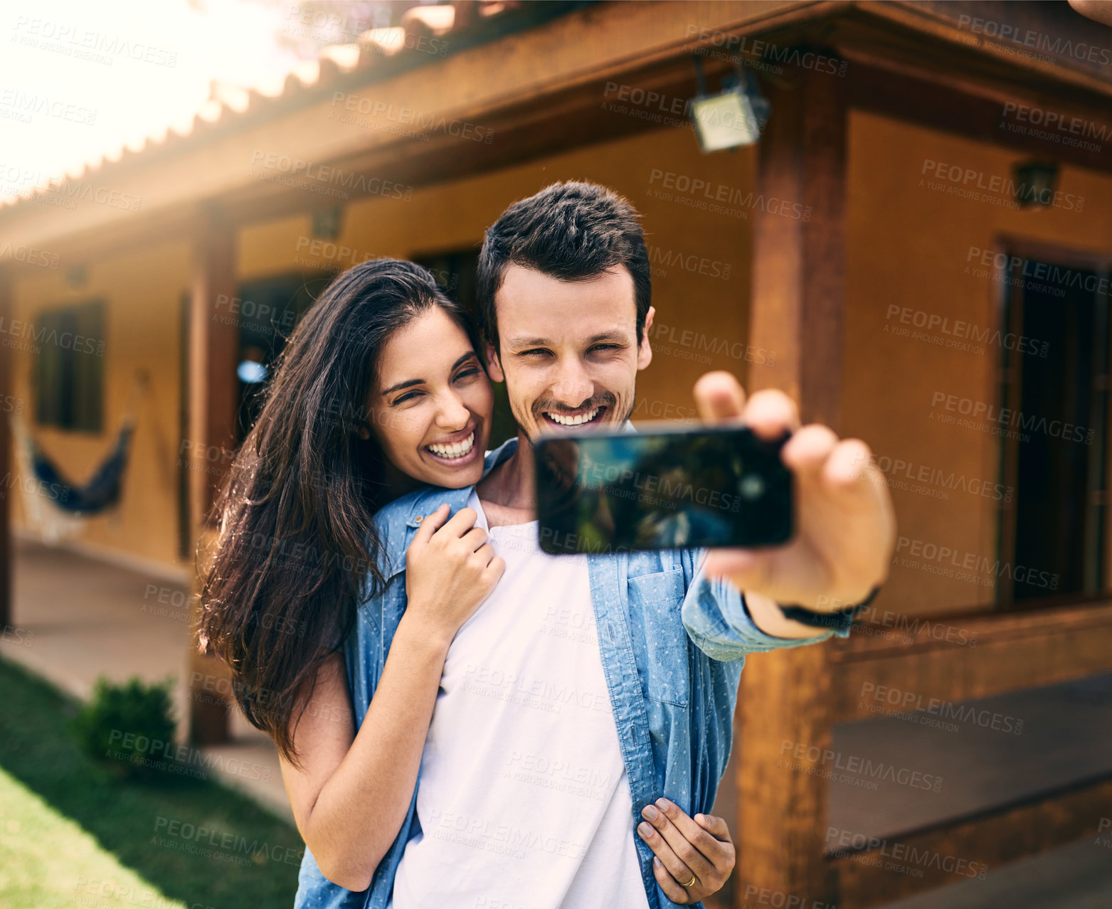 Buy stock photo Happy couple, hug and smile for selfie, photo or profile picture together and social media vlog outdoors. Man and woman hugging and smiling for memory, online post or capture with phone outside home