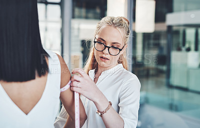 Buy stock photo Woman, fashion designer and arm with measuring tape for size at workshop or boutique store. Young, female person or tailor checking measurement on model or body for clothing line, style or production