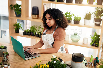 Buy stock photo High angle shot of an attractive young female botanist working on a laptop in her florist