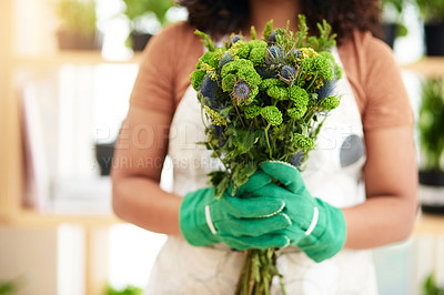 Buy stock photo Cropped shot of an unrecognizable young female botanist holding a bouquet of flowers while working in her florist