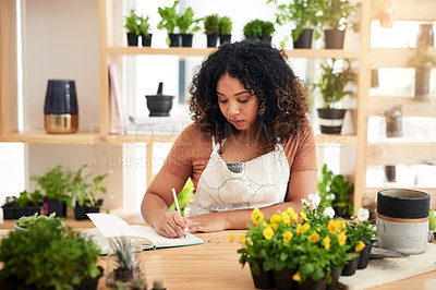 Buy stock photo Cropped shot of an attractive young female botanist making notes while working in her florist