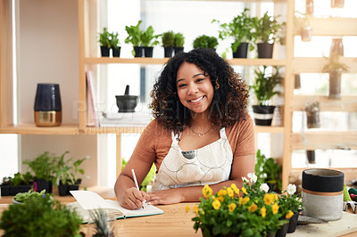 Buy stock photo Cropped portrait of an attractive young female botanist making notes while working in her florist