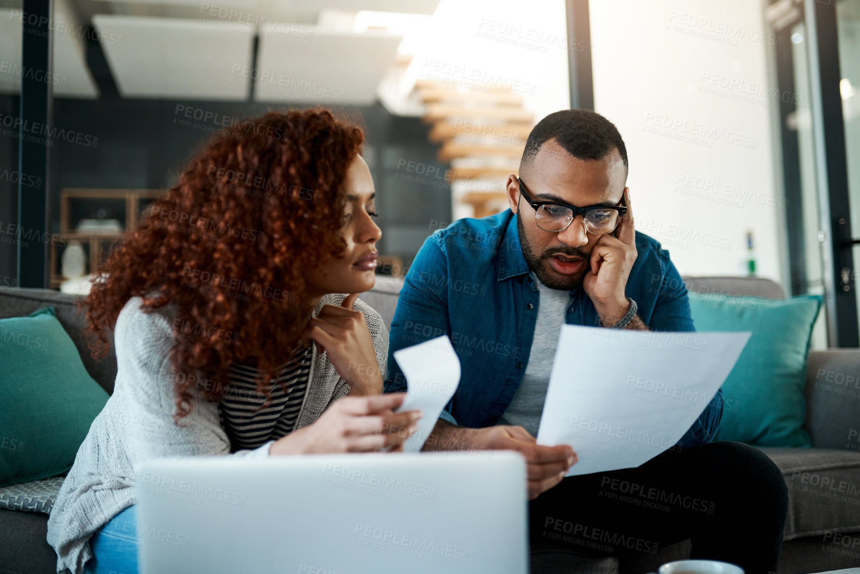 Buy stock photo Shot of a young couple planning their budget together at home