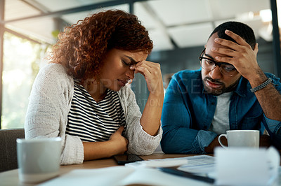 Buy stock photo Shot of a young couple looking stressed out while working on their budget at home
