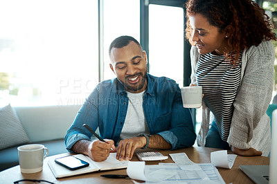 Buy stock photo Shot of a young couple planning their budget together at home
