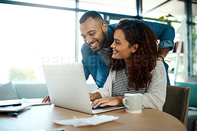 Buy stock photo Shot of a young couple planning their budget together on a laptop at home