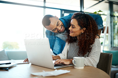 Buy stock photo Shot of a young couple planning their budget together on a laptop at home