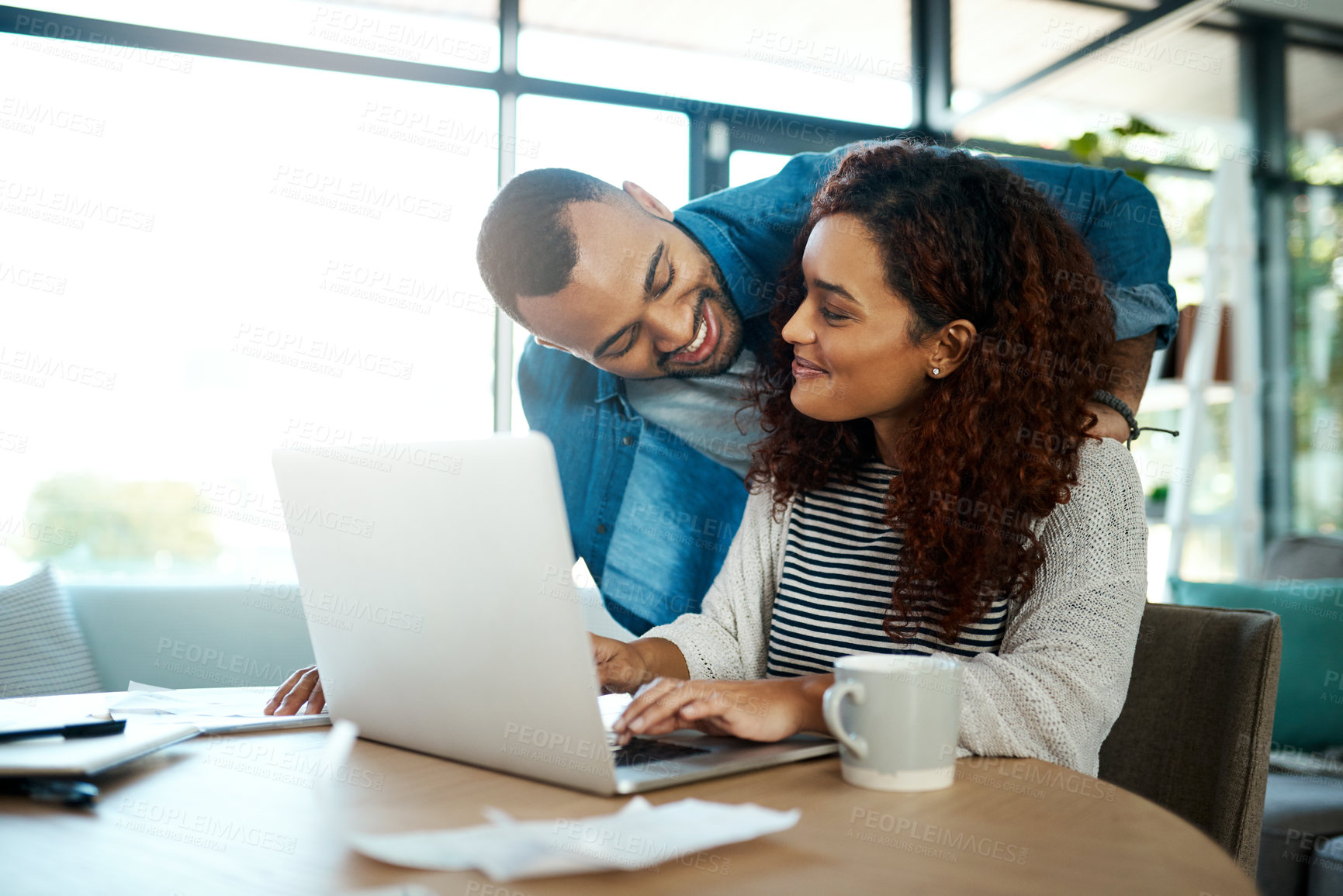 Buy stock photo Shot of a young couple planning their budget together on a laptop at home