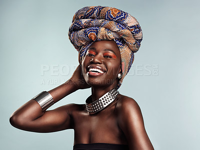 Buy stock photo Studio shot of a beautiful young woman wearing a traditional African head wrap against a grey background