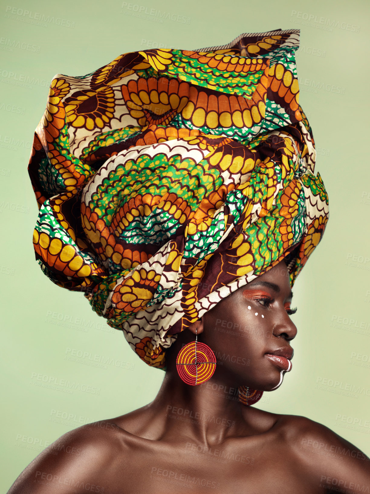 Buy stock photo Studio shot of a beautiful young woman wearing a traditional African head wrap against a green background
