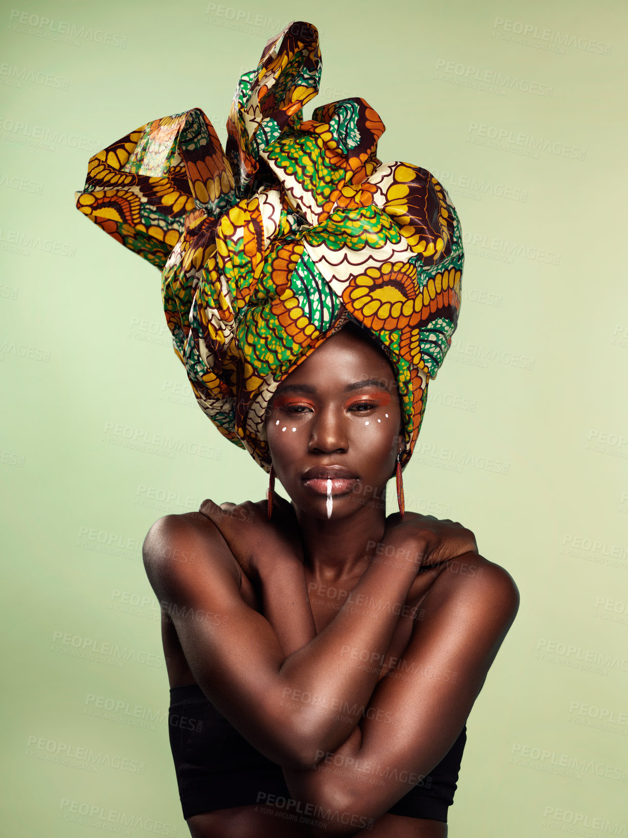 Buy stock photo Studio shot of a beautiful young woman wearing a traditional African head wrap against a green background