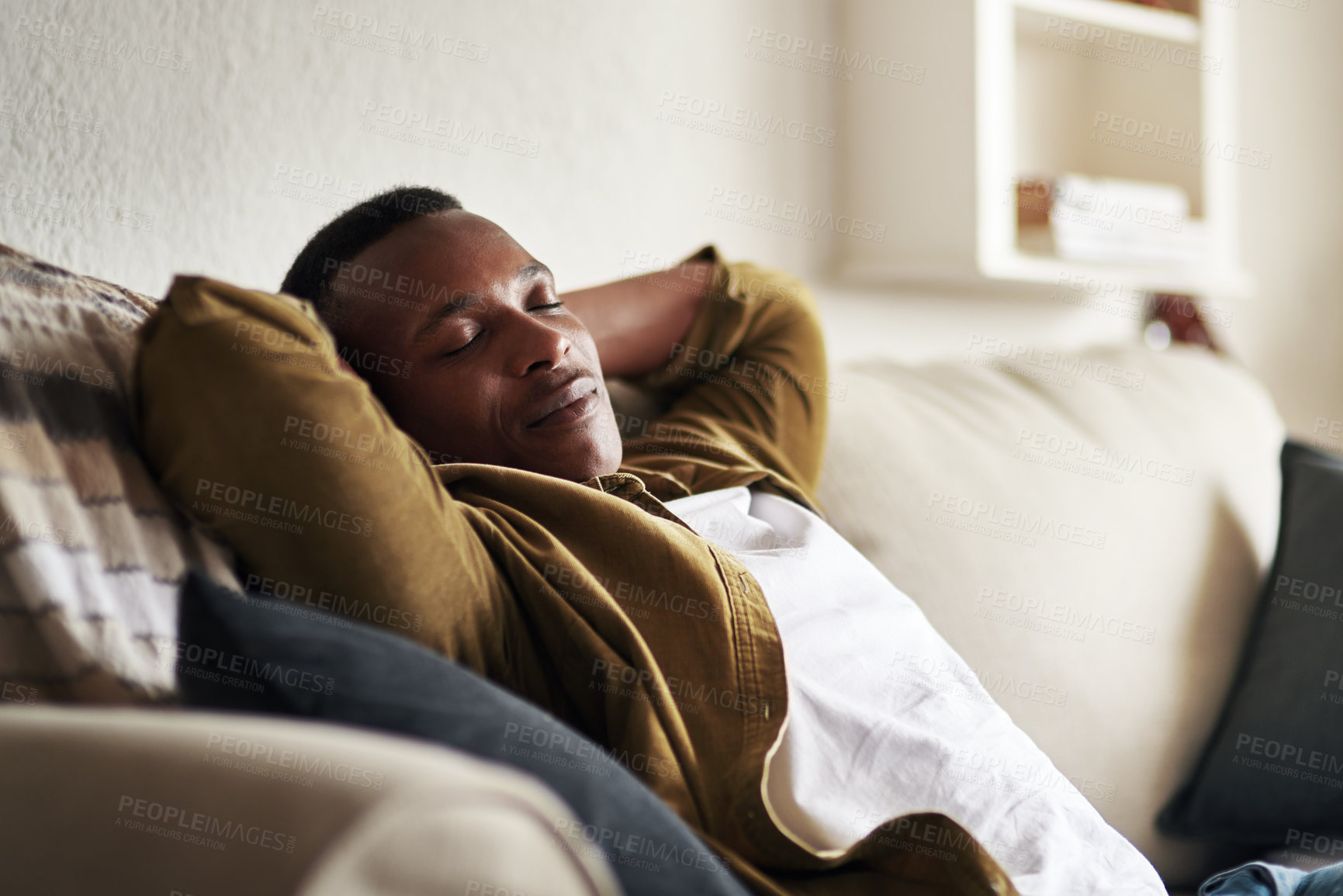 Buy stock photo Cropped shot of a handsome young man sleeping on the couch in his living room at home