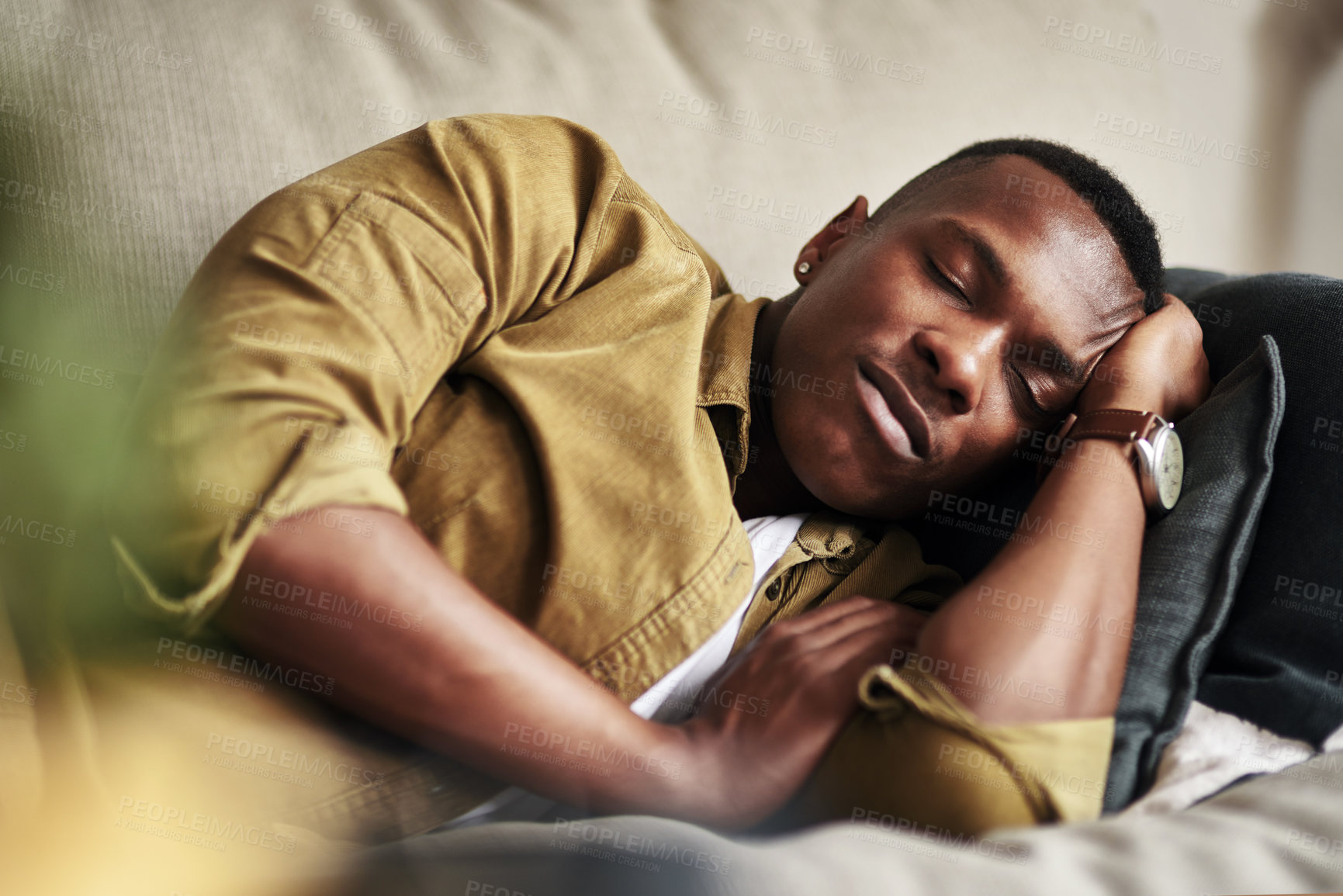 Buy stock photo Cropped shot of a handsome young man sleeping on the couch in his living room at home