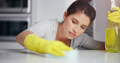 Buy stock photo Cropped shot of a young woman cleaning the kitchen surface at home