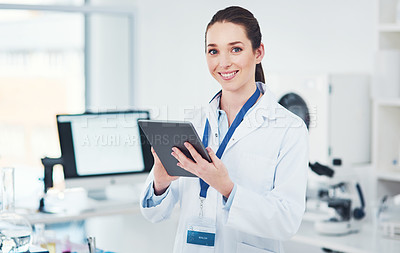 Buy stock photo Portrait of a focused young female scientist browsing on a digital tablet inside of a laboratory during the day