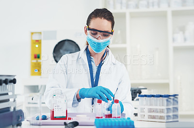 Buy stock photo Cropped shot of an unrecognizable young female scientist wearing protective fave gear while conducting experiments inside of a laboratory