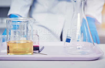 Buy stock photo Closeup of an unrecognizable scientist standing next to a tray of test tubes with chemicals in them ready to be used for experiments