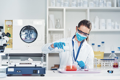 Buy stock photo Cropped shot of an unrecognizable young female scientist wearing protective face gear while conducting experiments inside of a laboratory