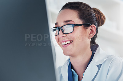 Buy stock photo Cropped shot of a focused young female scientist working on a computer inside of a laboratory during the day