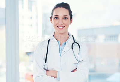 Buy stock photo Portrait of a cheerful young female doctor standing with her arms folded inside of a laboratory during the day