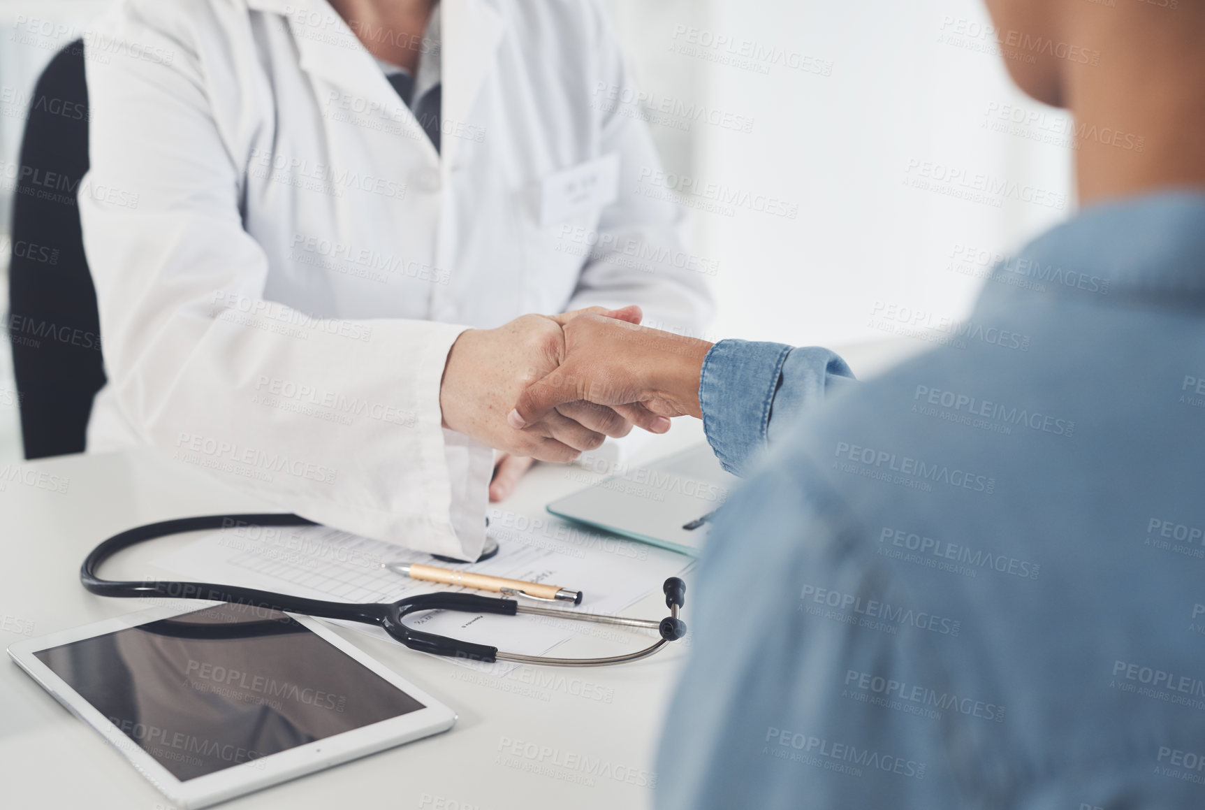 Buy stock photo Cropped shot of an unrecognizable female doctor shaking hands with a female patient in her office