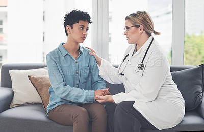 Buy stock photo Cropped shot of a compassionate young female doctor consoling a female patient while sitting on the couch in her office