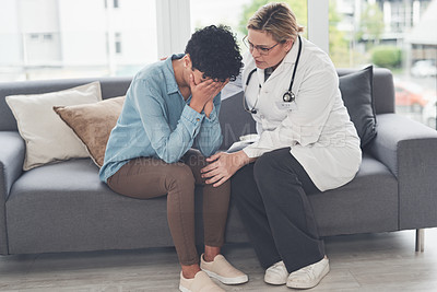 Buy stock photo Cropped shot of a compassionate young female doctor consoling a female patient while sitting on the couch in her office