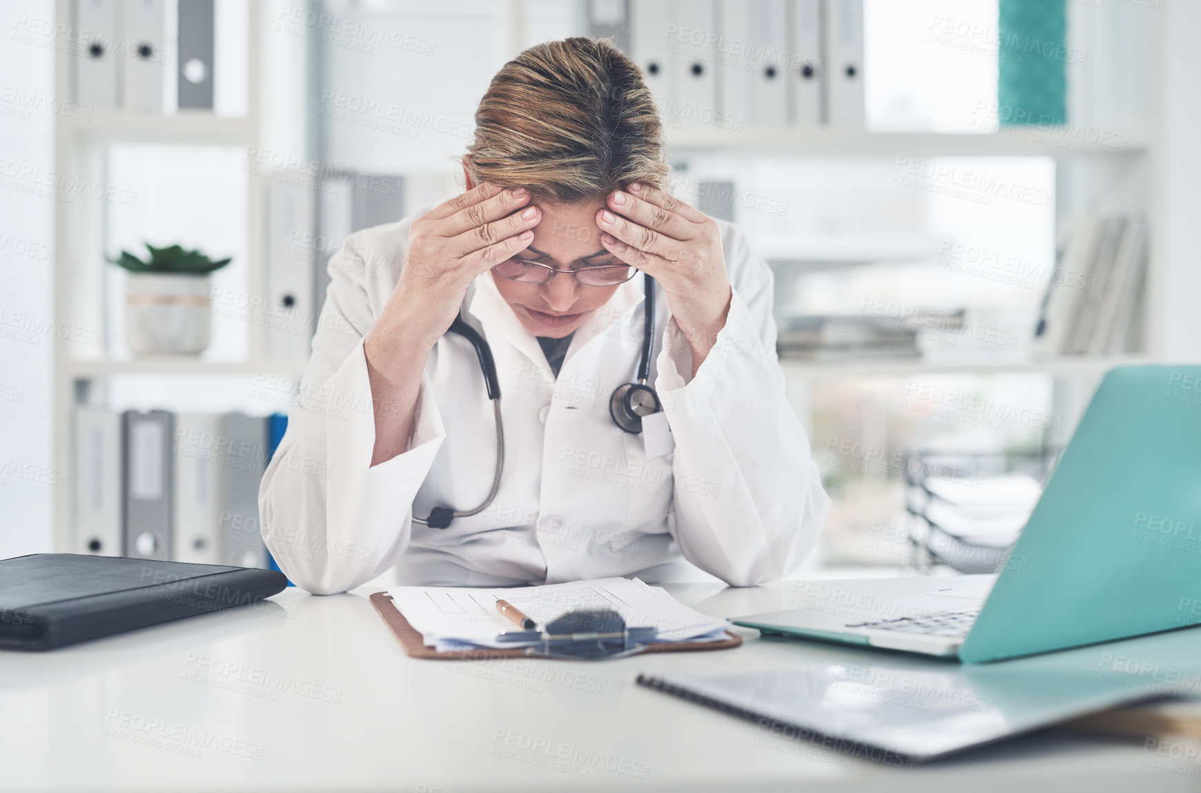Buy stock photo Cropped shot of an attractive young female doctor suffering with a headache while working in her office