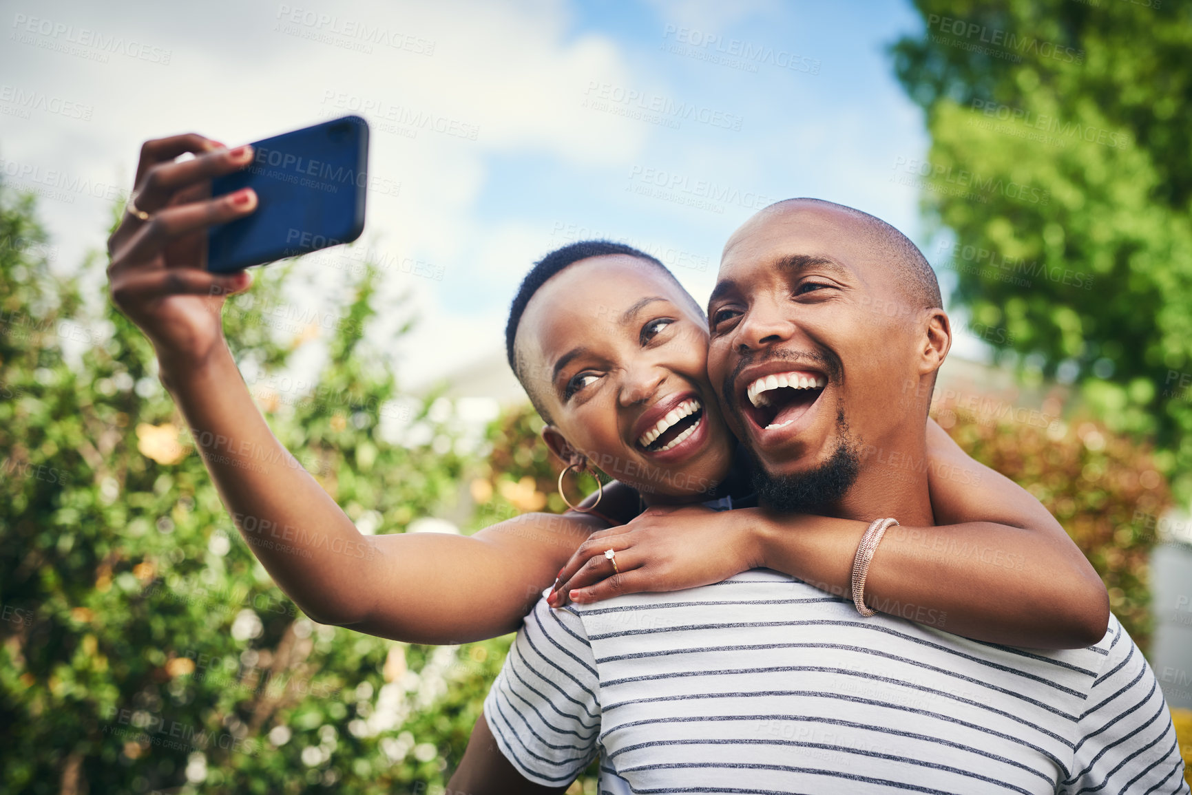 Buy stock photo Cropped shot of a happy young couple taking a selfie outside