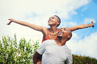 Buy stock photo Cropped shot of a young man giving his girlfriend a piggyback ride