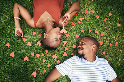 Buy stock photo Cropped shot of a young couple lying on the lawn outside