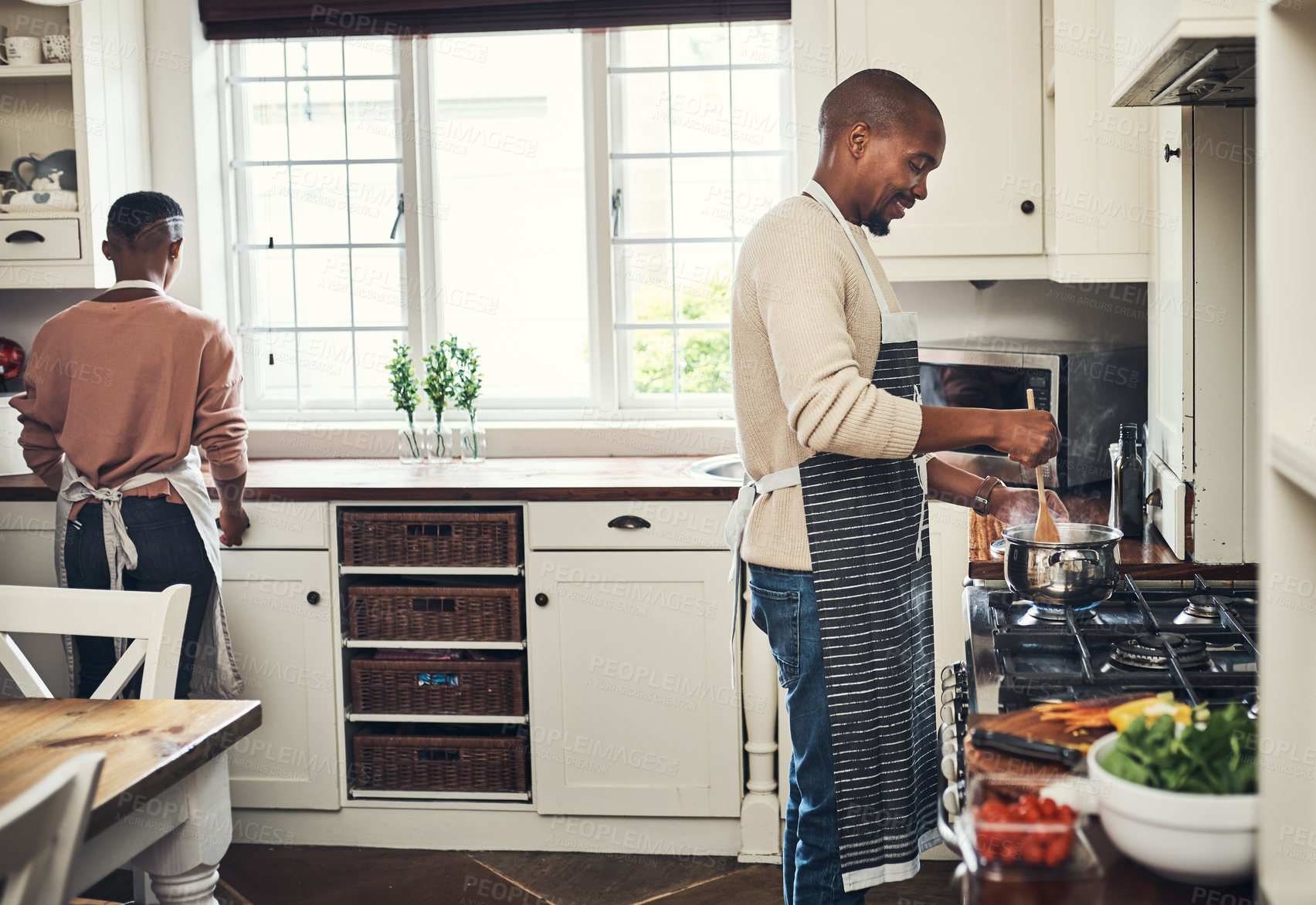 Buy stock photo Cropped shot of an affectionate young couple preparing dinner in their kitchen