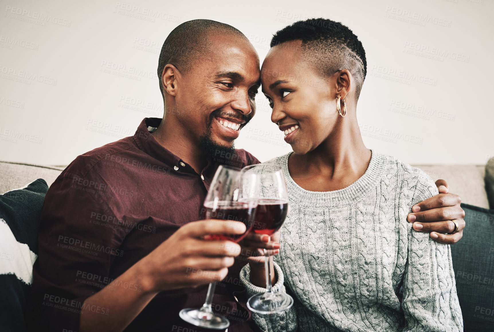 Buy stock photo Shot of a happy young couple drinking wine and relaxing together at home