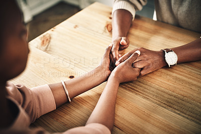 Buy stock photo Cropped shot of an unrecognizable couple holding hands on a table at home