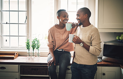 Buy stock photo Shot of a happy young couple drinking coffee and spending time together at home