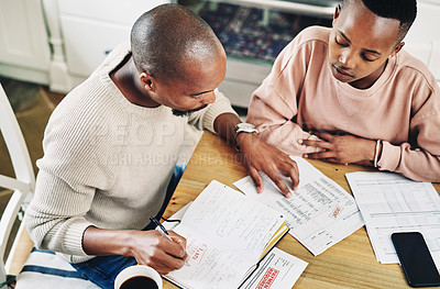 Buy stock photo Shot of a young couple going over their bills and finances together at home