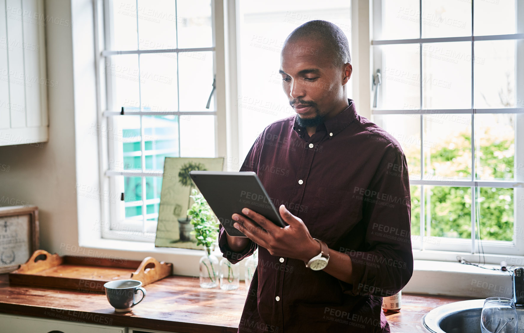 Buy stock photo Black man, tablet and typing in kitchen for remote work, ecommerce and online banking in app. Person, tech and reading in home for contact, social media and research job opportunity on internet