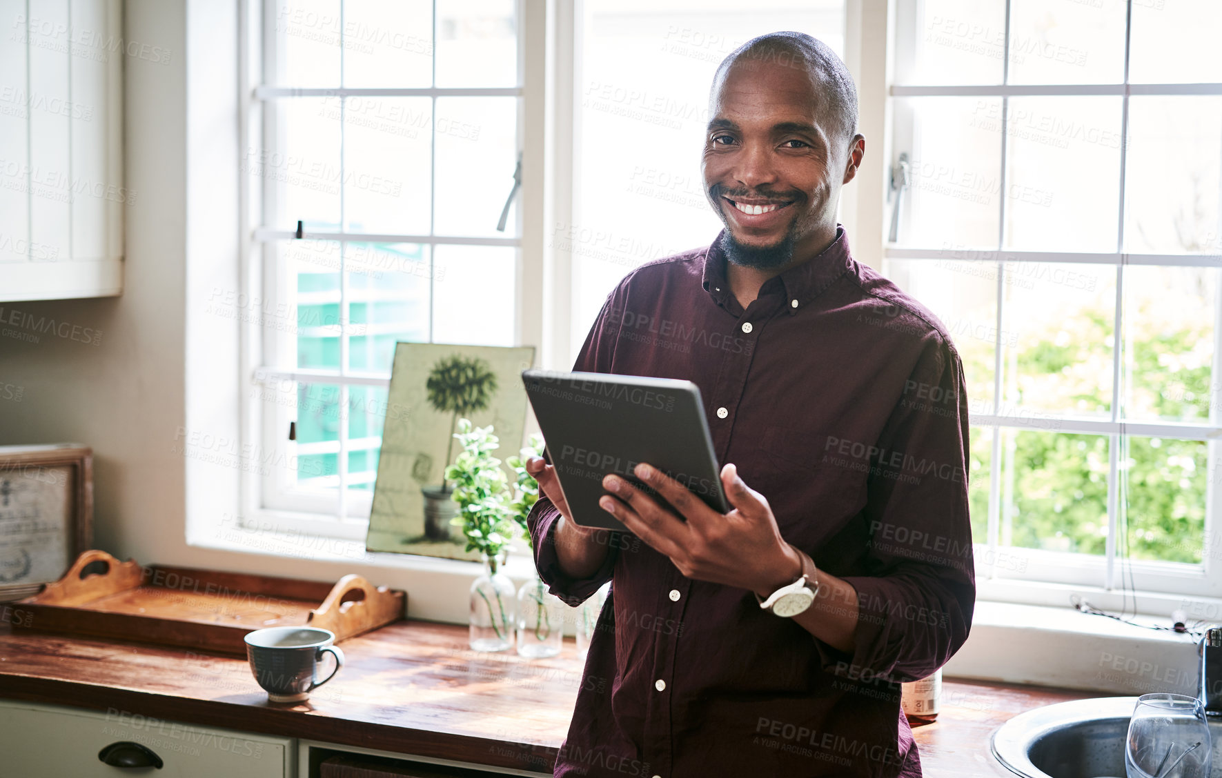 Buy stock photo Black man, tablet or portrait in kitchen for remote work, ecommerce or online banking in app. Person, tech or happy in home for email, social media or research job opportunity on internet in Nigeria