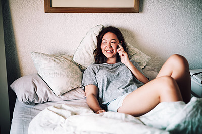 Buy stock photo Cropped shot of an attractive young woman smiling while taking a phonecall in her bedroom at home