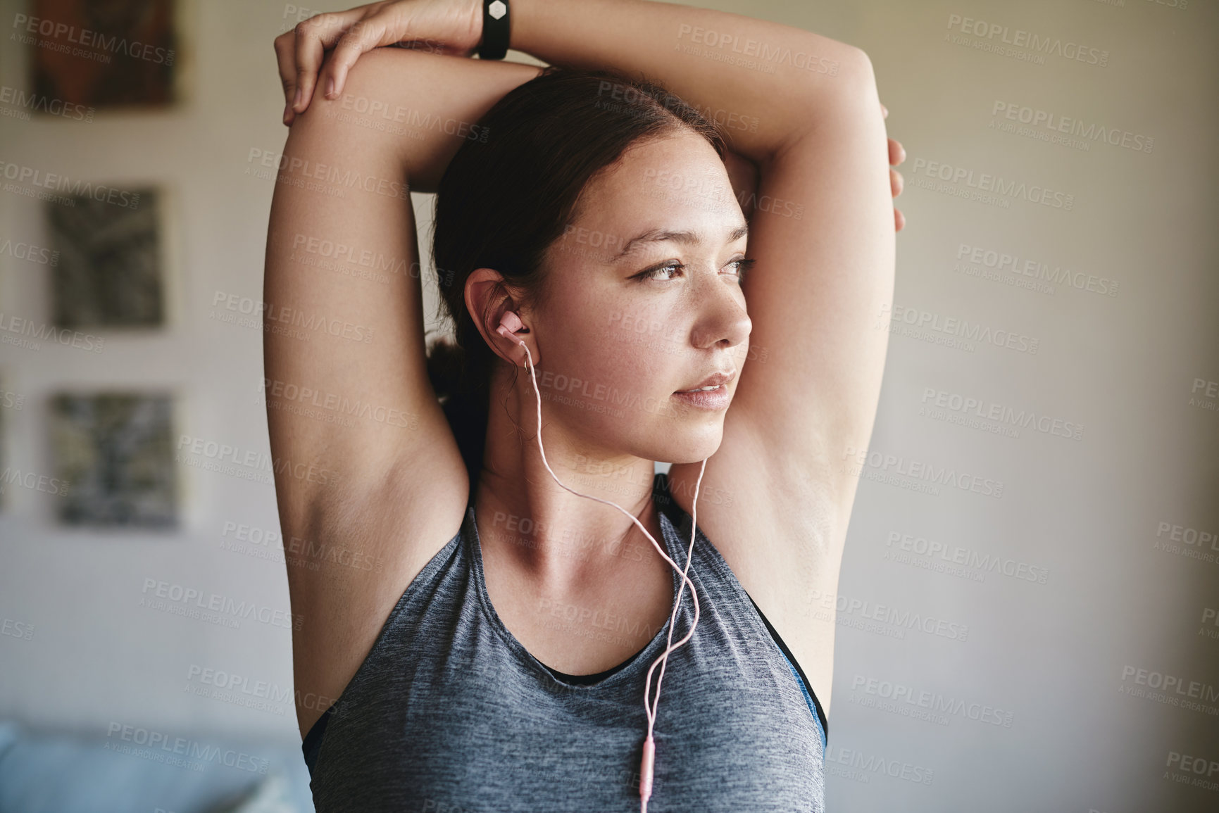Buy stock photo Cropped shot of an attractive young woman standing in her room and stretching her tricep after a workout at home