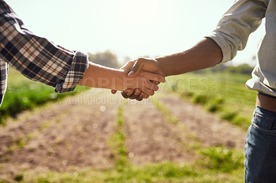 Buy stock photo Cropped shot of two unrecognizable farmers shaking hands while working on their farm