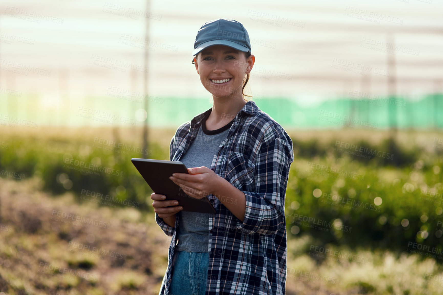 Buy stock photo Cropped portrait of an attractive young female farmer using a tablet while working on her farm