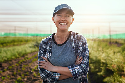 Buy stock photo Cropped portrait of an attractive young female farmer standing with her arms crossed while working on the farm