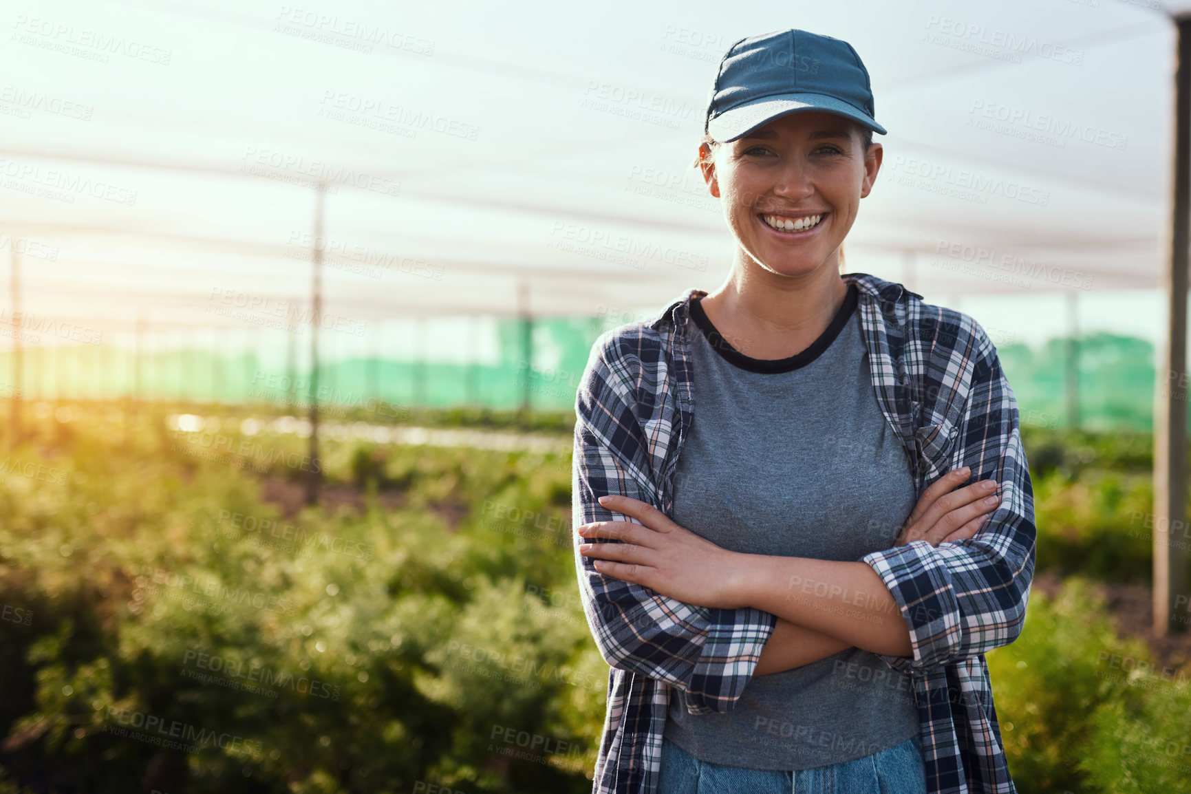 Buy stock photo Cropped portrait of an attractive young female farmer standing with her arms crossed while working on the farm