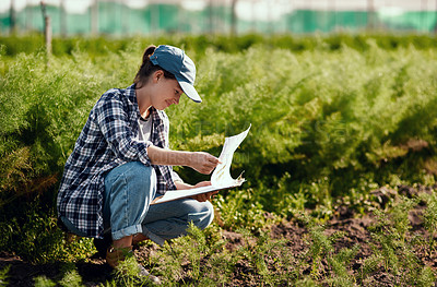 Buy stock photo Young female farmer preparing for harvest while working on her farm field ensuring the organic soil is fresh and sustainable outside. Happy worker reading her clipboard notes to check farming land