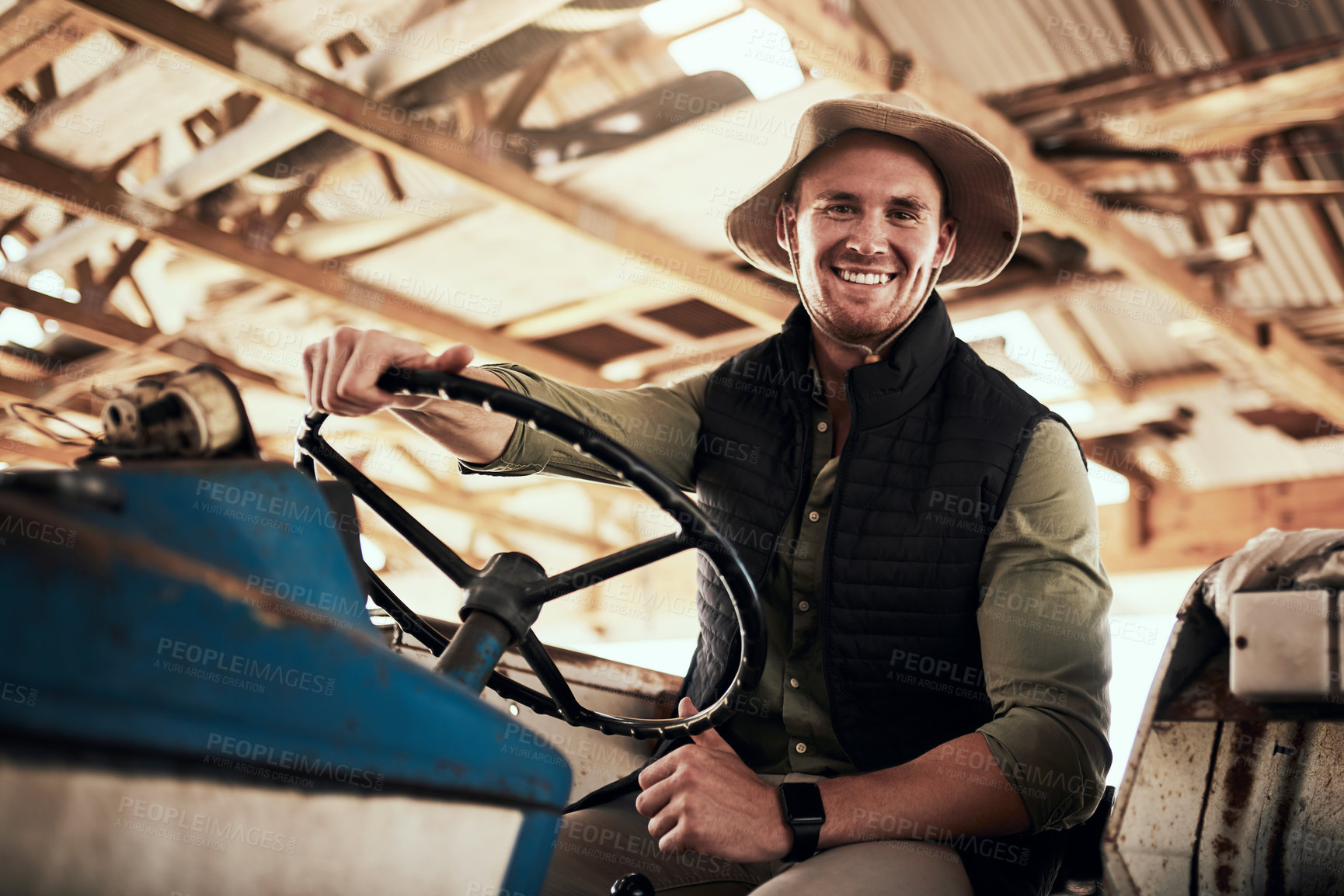 Buy stock photo Portrait of a handsome young farmer posing while sitting inside a tractor at his farm