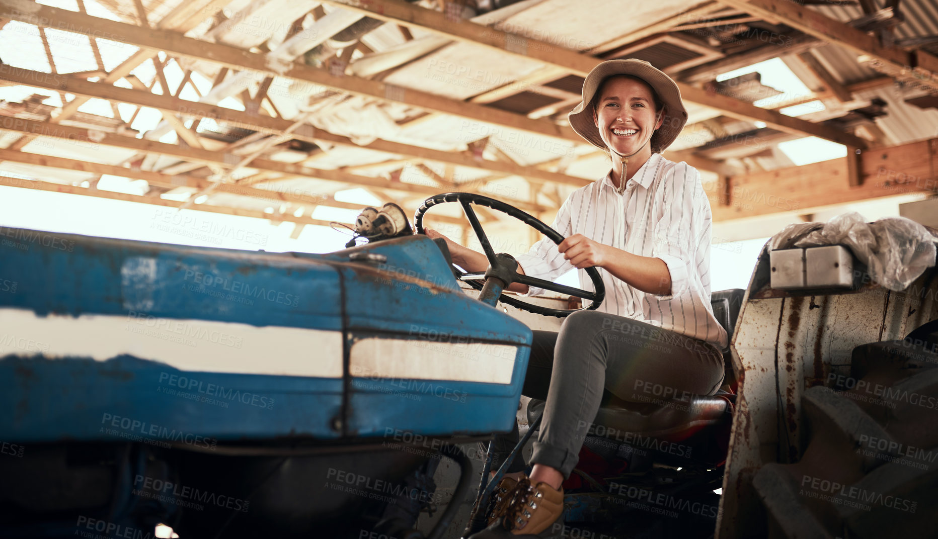 Buy stock photo Portrait of an attractive young female farmer posing while siting inside a tractor at her farm