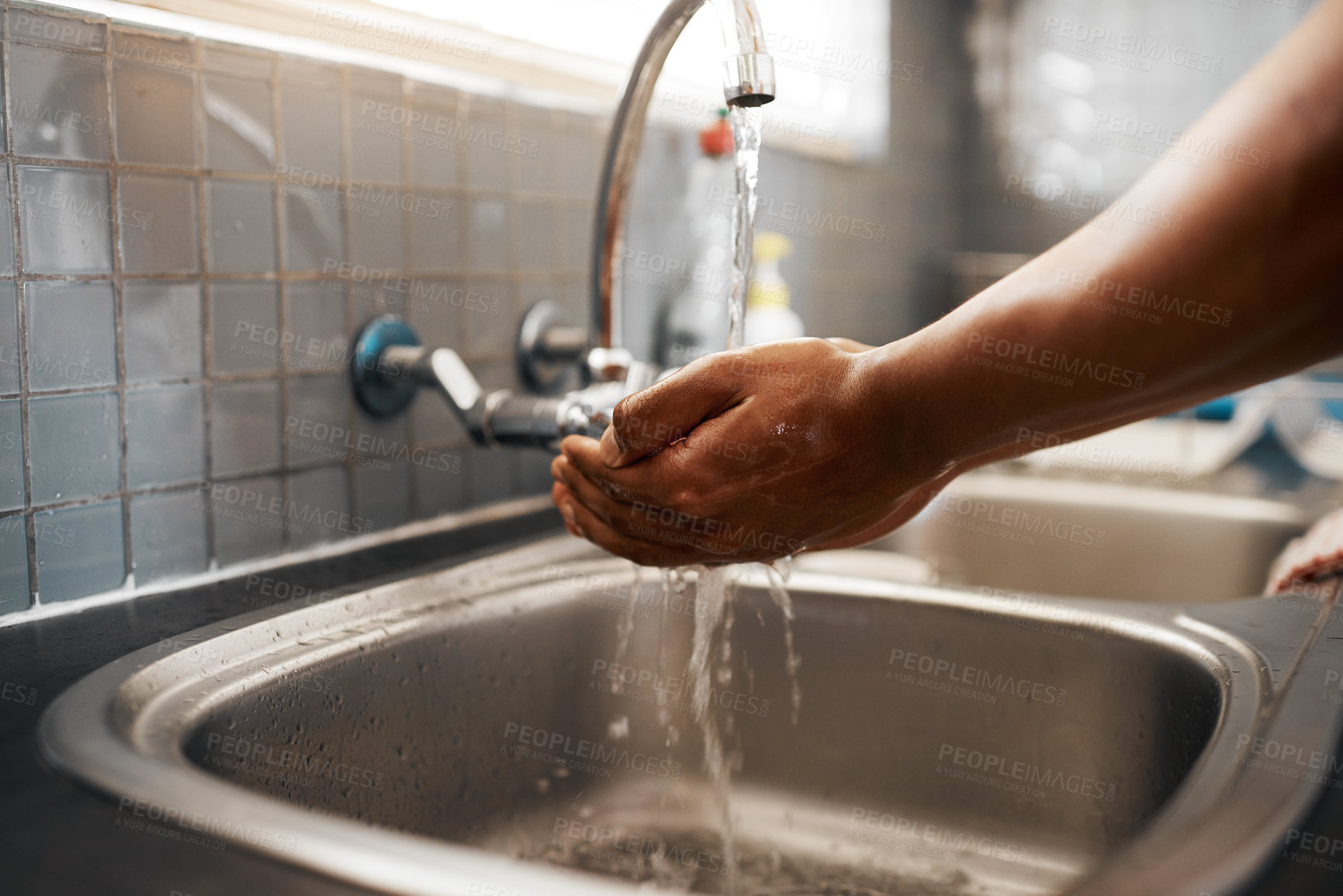 Buy stock photo Cropped shot of an unrecognizable man washing his hands in the kitchen sink at home