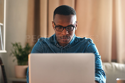 Buy stock photo Freelance blogger typing on laptop, thinking of blog post or planning off story vision while working from home living room. Serious, ambitious or inspired writer or entrepreneur working on technology